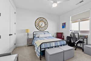 Bedroom featuring a closet, light carpet, and ceiling fan