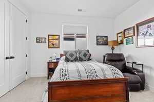 Bedroom with light carpet and a closet