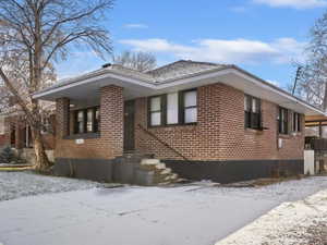 View of snow covered exterior with brick siding