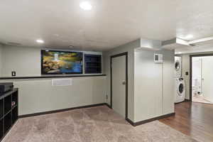 Home theater with stacked washer / drying machine, recessed lighting, and hardwood / wood-style flooring