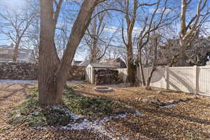 Fenced backyard featuring a shed