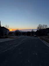 View of asphalt street featuring curbs, sidewalks, and a residential view