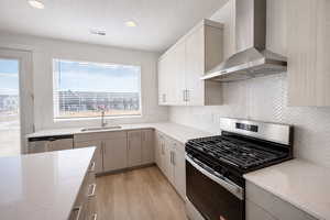 Kitchen featuring stainless steel appliances, light wood-style flooring, light stone countertops, recessed lighting, and a textured ceiling