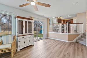 Living area featuring light wood finished floors, ceiling fan, and a textured ceiling