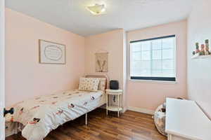 Bedroom featuring dark wood finished floors and a textured ceiling