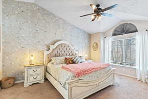 Carpeted bedroom with a ceiling fan and wallpapered walls