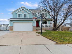 Traditional-style house with driveway, brick siding, and an attached garage