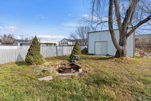 Fenced backyard with a fire pit and a shed