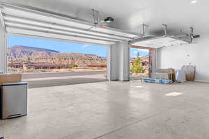 Garage with a mountain view, stainless steel refrigerator, and a garage door opener