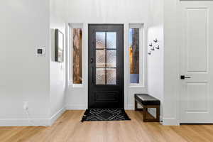 Foyer with wood finished floors and baseboards