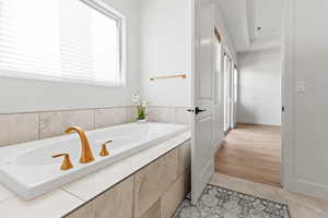 Bathroom with a bath and light tile patterned flooring