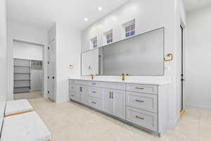 Full bathroom with a walk in closet, vanity, light tile patterned floors, and recessed lighting