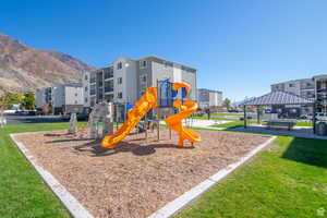Community playground featuring a yard, a mountain view, and a patio