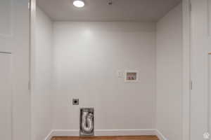 Laundry area featuring hookup for an electric dryer, wood finished floors, and washer hookup