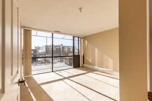 Unfurnished room featuring a city view and floor to ceiling windows