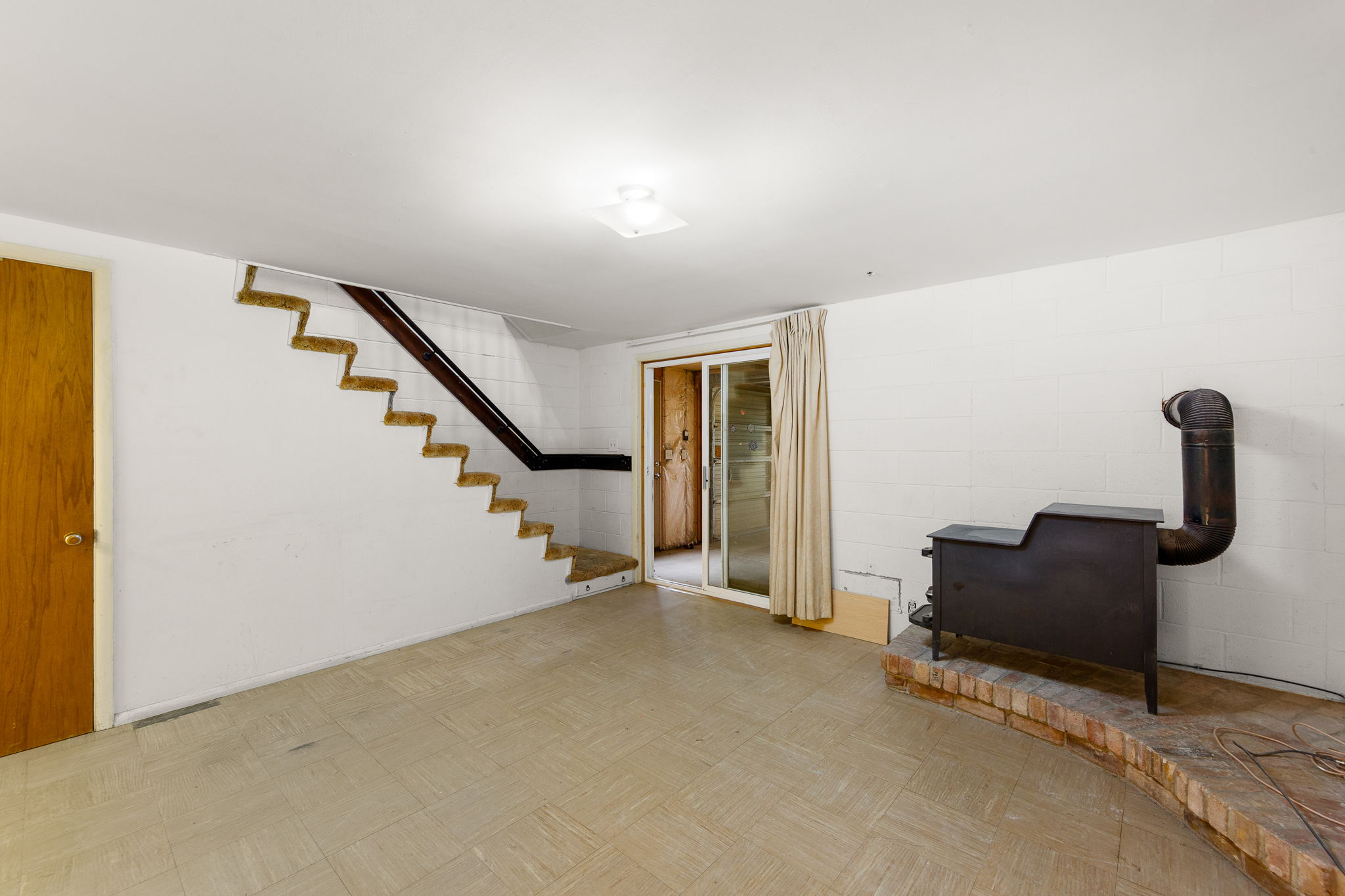 Basement with stairs and a wood stove