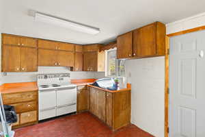 Kitchen featuring range with two ovens, light countertops, and wood finish cabinets