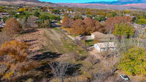 Aerial view of property and surrounding area featuring a mountain backdrop and nearby suburban area