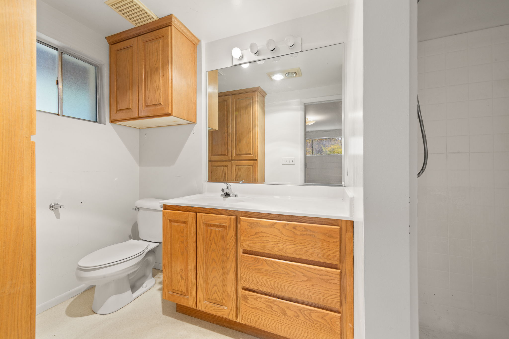 Full bath featuring vanity and tiled shower