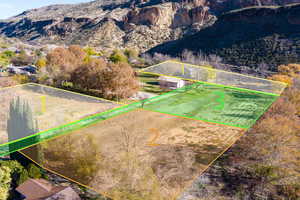 Aerial overview of property's location with a mountainous background and property boundaries highlighted