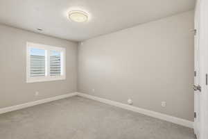 Carpeted empty room with baseboards and a textured ceiling