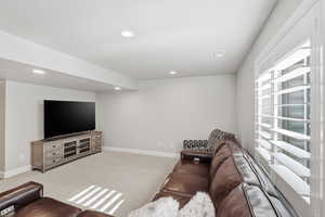 Living room with light colored carpet and recessed lighting