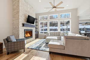 Living area with light wood finished floors, ceiling fan, healthy amount of natural light, a fireplace, and recessed lighting