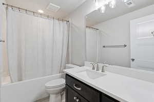 Bathroom with vanity and shower / bath combination with curtain