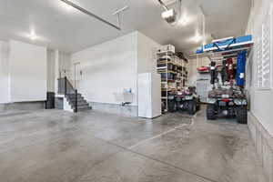Garage featuring freestanding refrigerator and a garage door opener