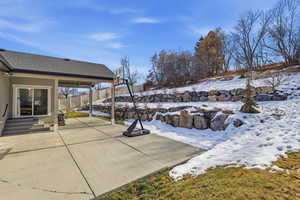 Snow covered patio featuring a patio area