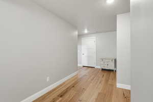 Hall with baseboards and light wood-type flooring
