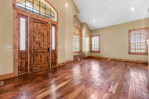 Foyer entrance with dark wood-style flooring, lofted ceiling, and recessed lighting