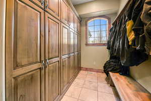 Mudroom with light tile patterned floors and baseboards