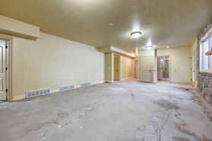 Unfurnished room featuring a textured ceiling and concrete flooring