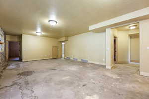 Unfurnished room featuring a textured ceiling and concrete flooring