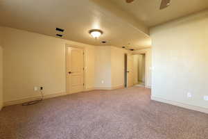 Empty room featuring light carpet, a textured ceiling, and ceiling fan