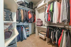 Walk in closet with light colored carpet