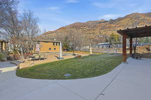 View of community featuring a patio area, a mountain view, and outdoor dining area