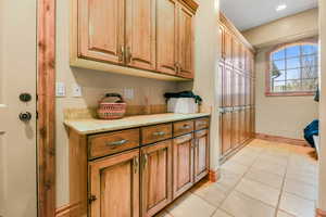 Laundry room featuring baseboards and light tile patterned flooring