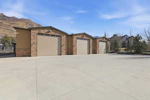 View of front of property with driveway and stone siding