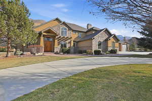 Craftsman-style house featuring stucco siding, stone siding, and a mountain view