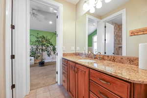 Full bath featuring vanity, light carpet, light tile patterned floors, ceiling fan, and suspended lighting