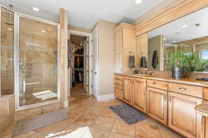 Bathroom with a stall shower, vanity, a spacious closet, recessed lighting, and stone tile floors