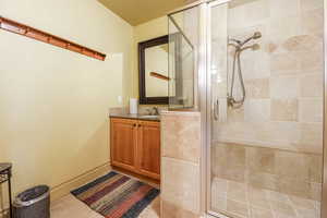 Bathroom featuring a stall shower, vanity, and light tile patterned floors