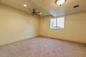 Unfurnished room featuring light carpet, a ceiling fan, a textured ceiling, and recessed lighting