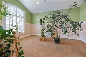 Unfurnished room featuring wainscoting, lofted ceiling, carpet floors, and recessed lighting