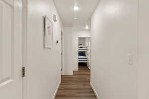 Hall with dark wood-style floors and a textured wall