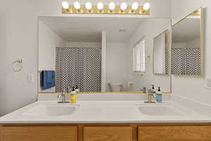 Bathroom with double vanity and a shower with curtain