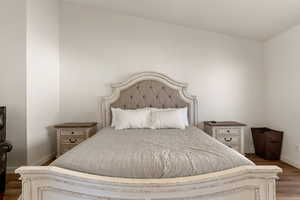 Bedroom with dark wood-type flooring and baseboards