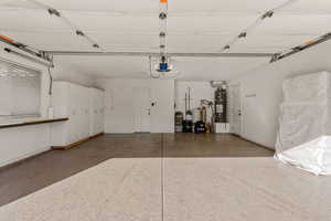 Garage with strapped water heater and a garage door opener